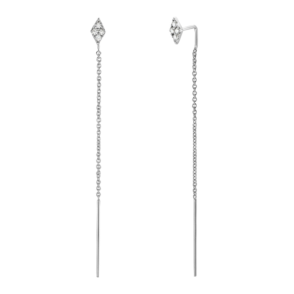 A pair of 14K white gold diamond threader earrings with a diamond-shaped stud and a long chain threading through the ear, ending in a polished gold bar.