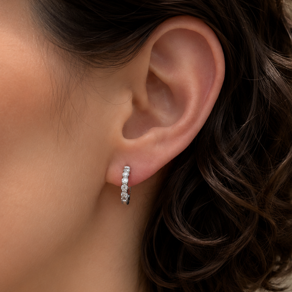 Diamond huggie hoop earrings on a model.