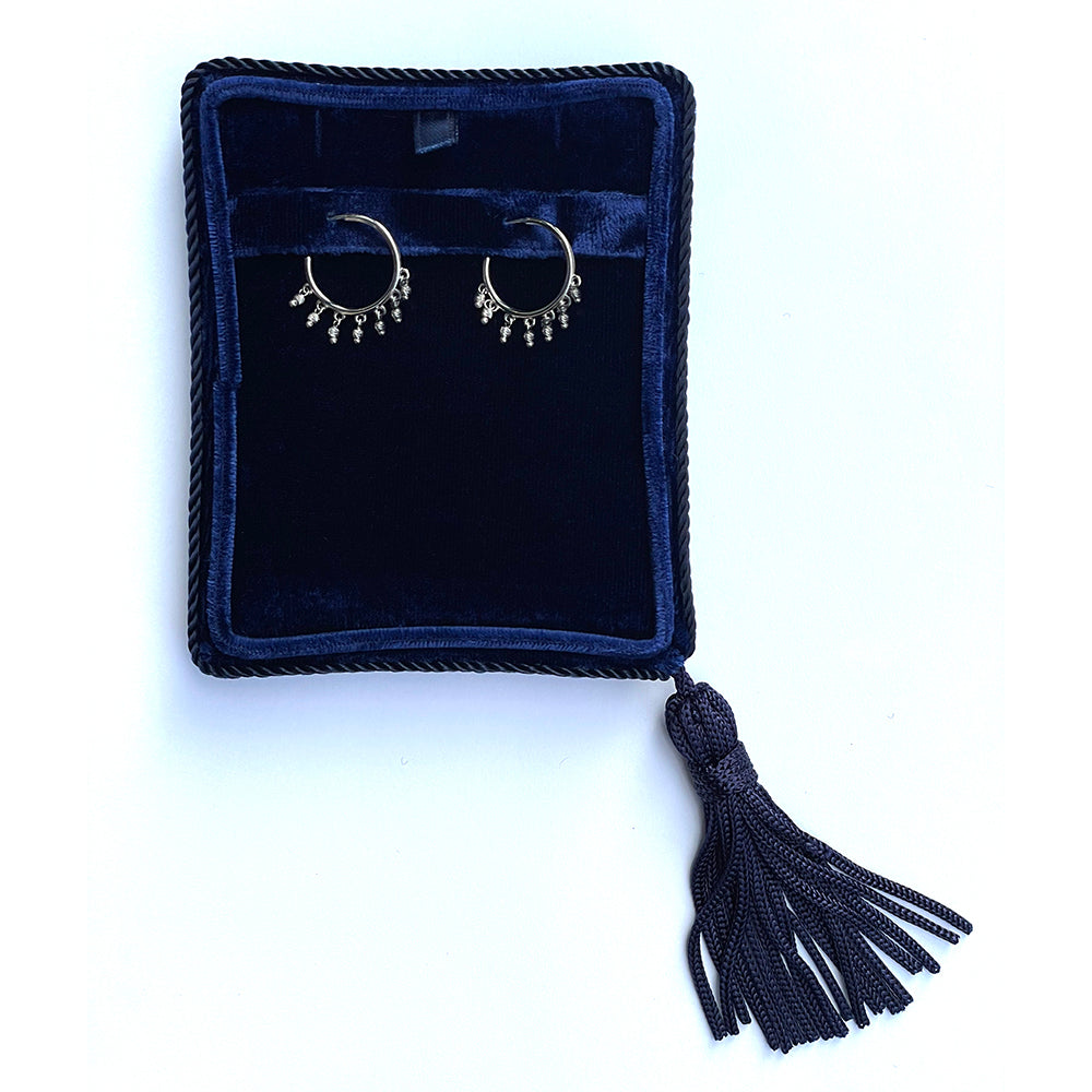 14K White Gold open hoop beaded earrings with dangling diamond-cut bead accents shown in a jewelry box