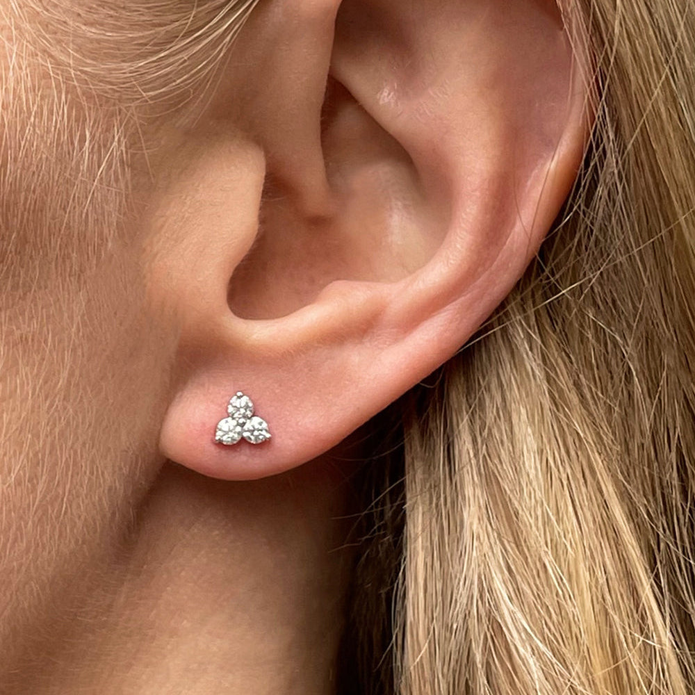 Model wearing 0.40 carat total weight diamond trilogy stud earrings featuring three round brilliant cut diamonds in a cluster design