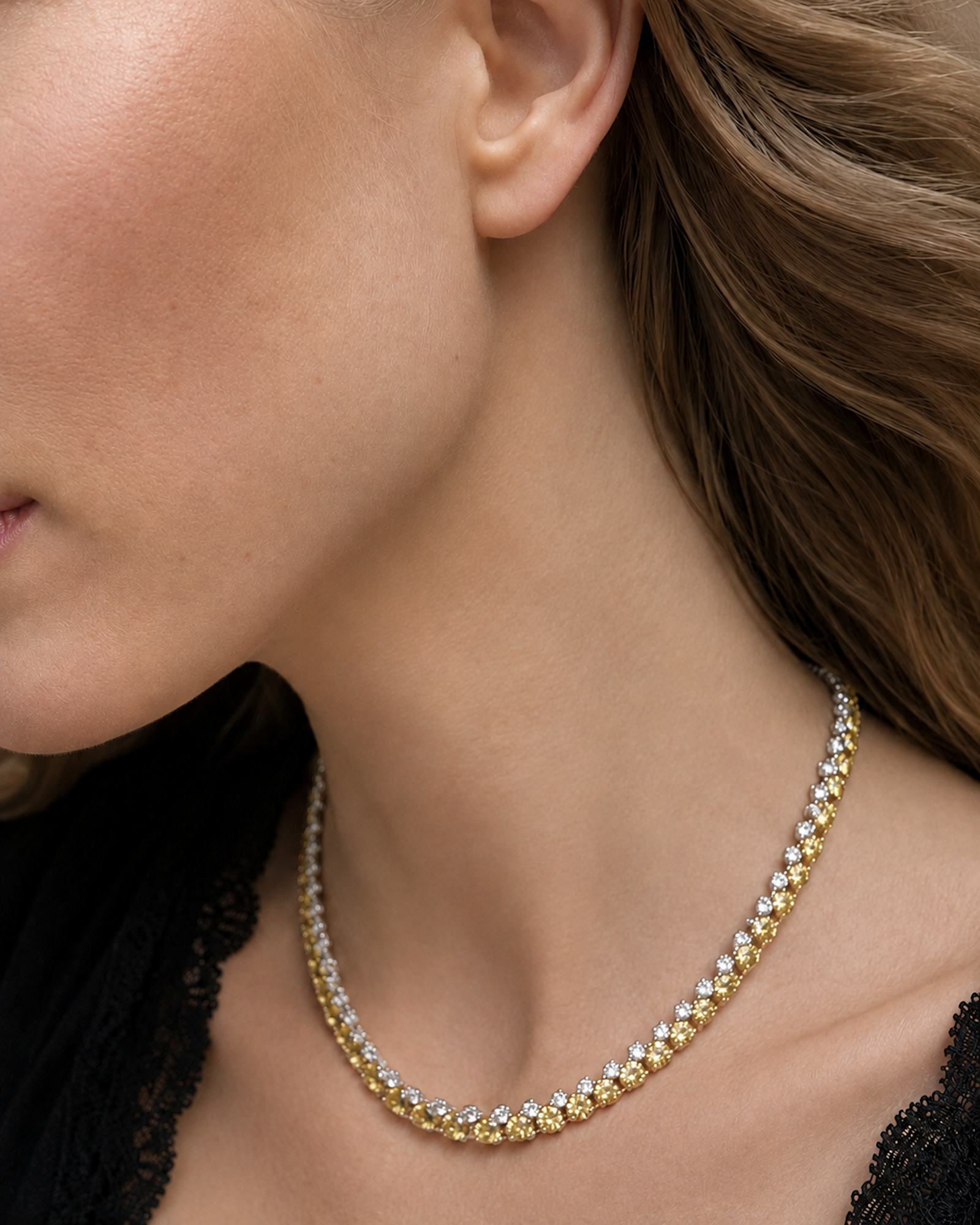 Side view of an alternating white and yellow diamond tennis necklace featuring natural round brilliant white and yellow diamonds in 18K white and yellow gold.