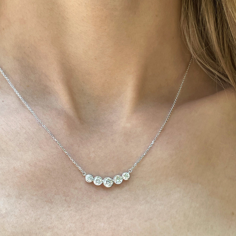 Close-up of a model wearing the Bezel Set Diamond Curved Bar Necklace in 14K white gold (0.80 TCW).