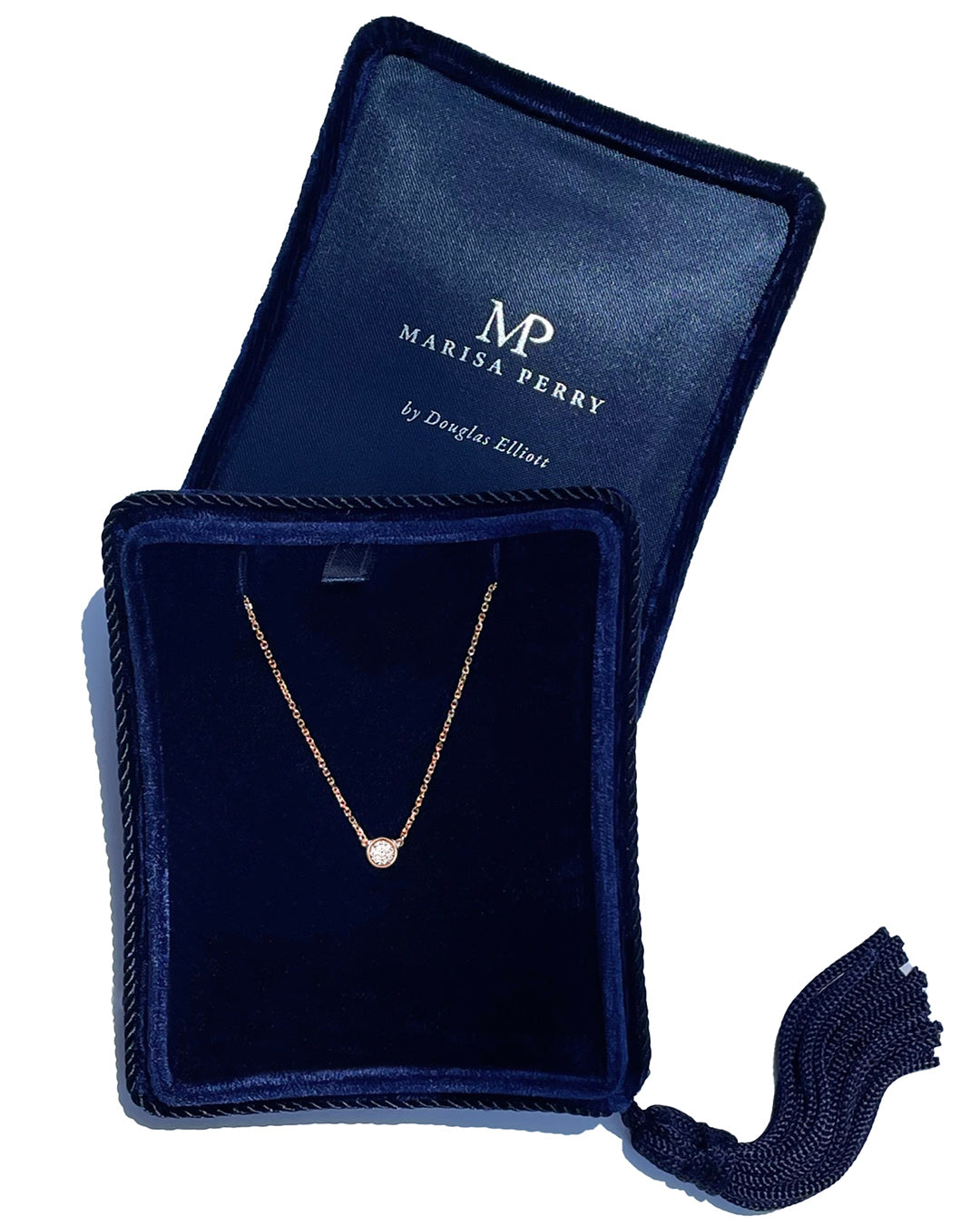 A delicate 14k rose gold chain necklace with a 0.25 carat round brilliant-cut diamond bezel set pendant, displayed inside a dark navy velvet jewelry box with a tassel.