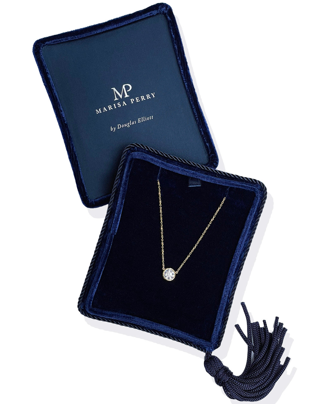 A delicate 14k yellow gold chain necklace with a 0.75 carat round brilliant-cut diamond bezel set pendant, displayed inside a dark navy velvet jewelry box with a tassel.