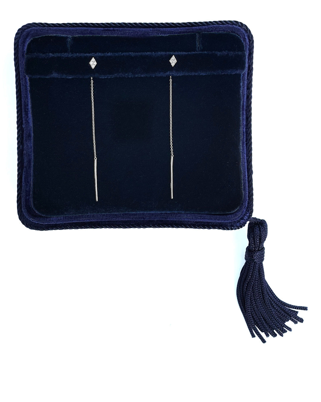 A pair of long, delicate, white gold diamond cluster threader earrings, displayed in a navy velvet Marisa Perry jewelry box with a tassel.