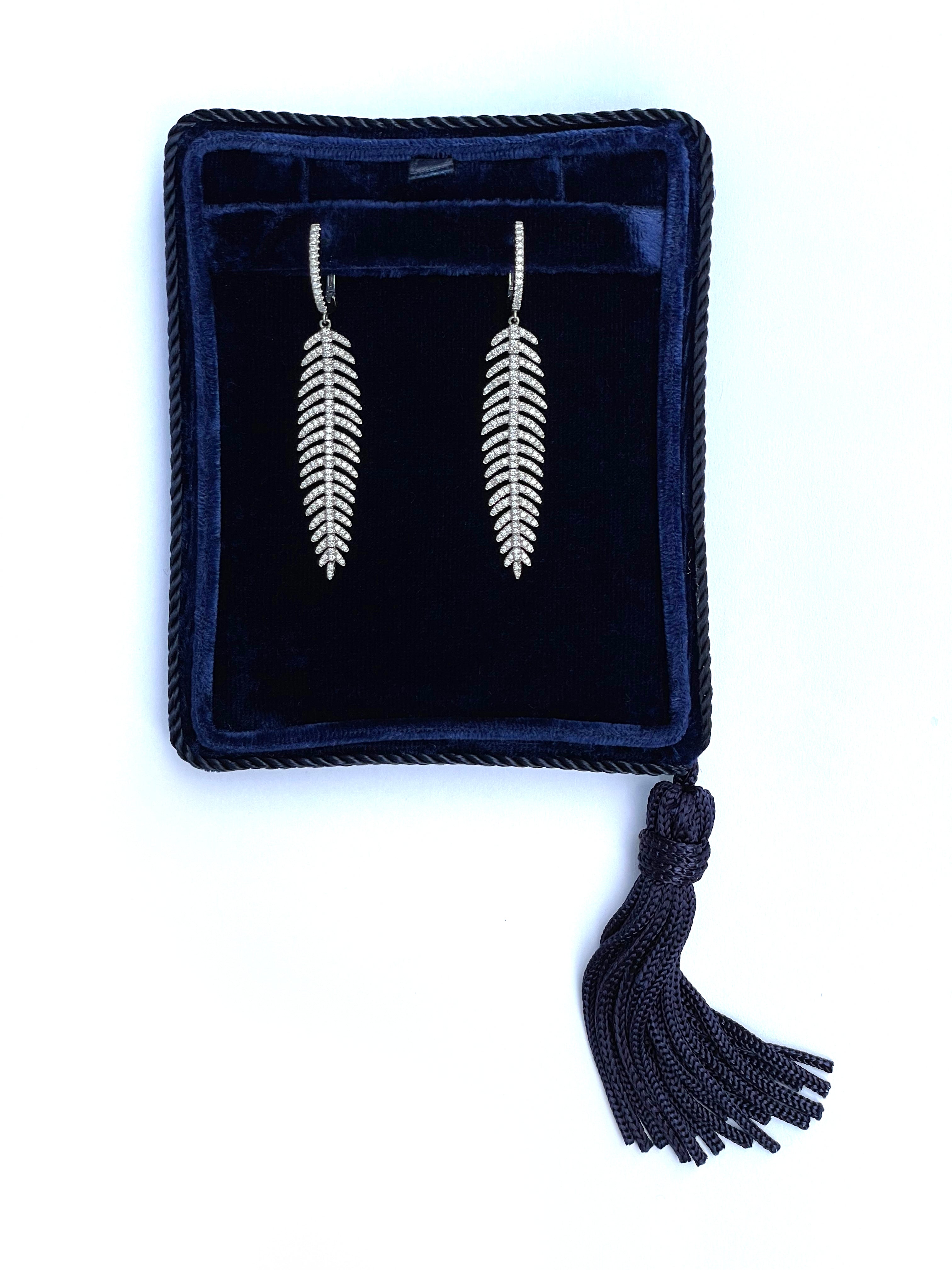 Diamond feather quill earrings in 14K white gold displayed in a navy velvet jewelry box.