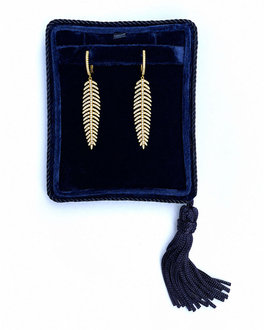 Diamond feather quill earrings in a navy Marisa Perry jewelry box.