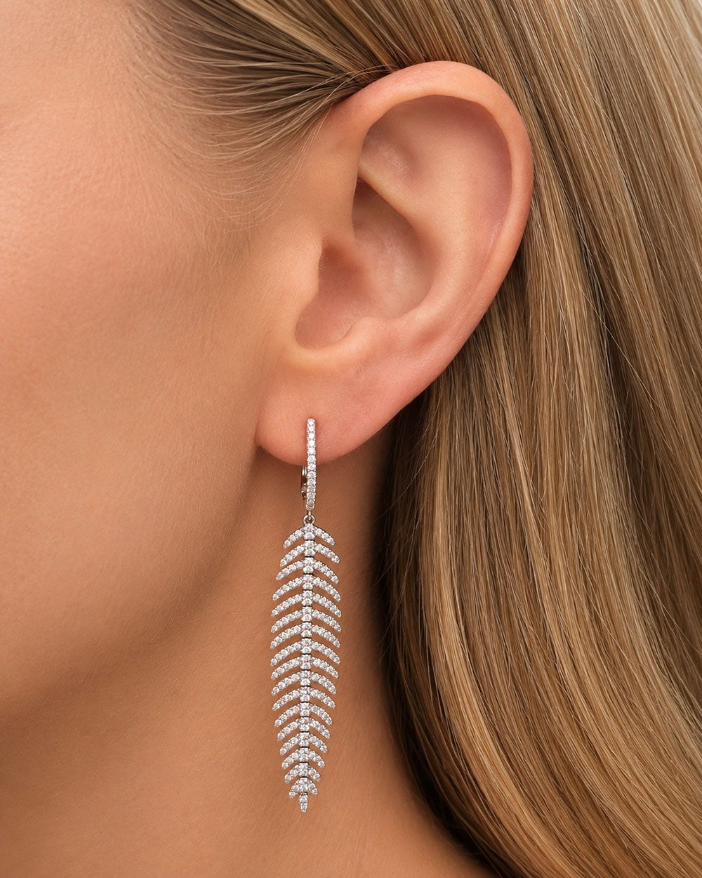 Model wearing 18K white gold diamond feather quill earrings with pavé round brilliant diamonds.