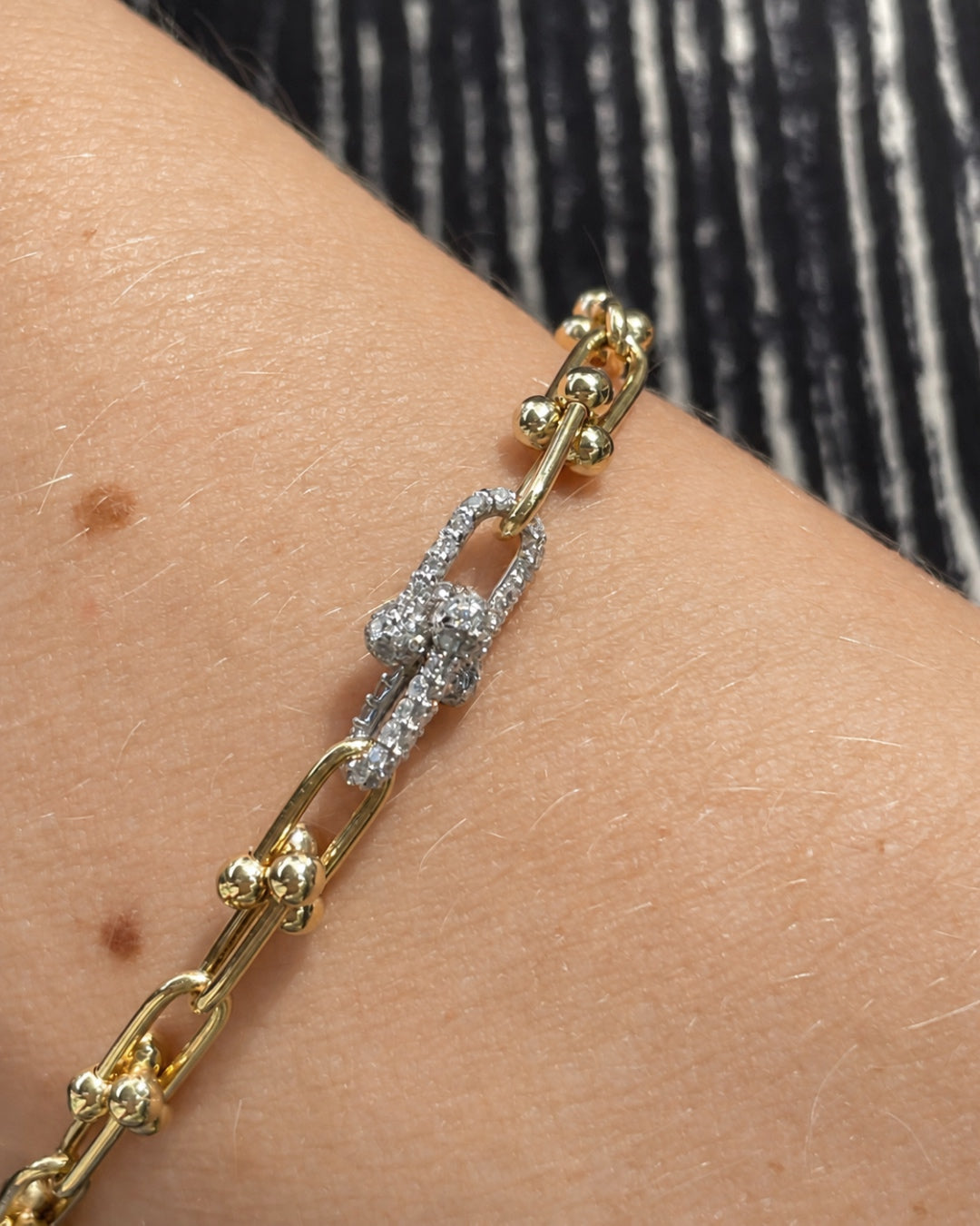 Close-up of the Diamond and Gold Ball Link Bracelet in 14K yellow gold, highlighting the diamond-set links and polished gold ball accents, shown on a model's wrist.