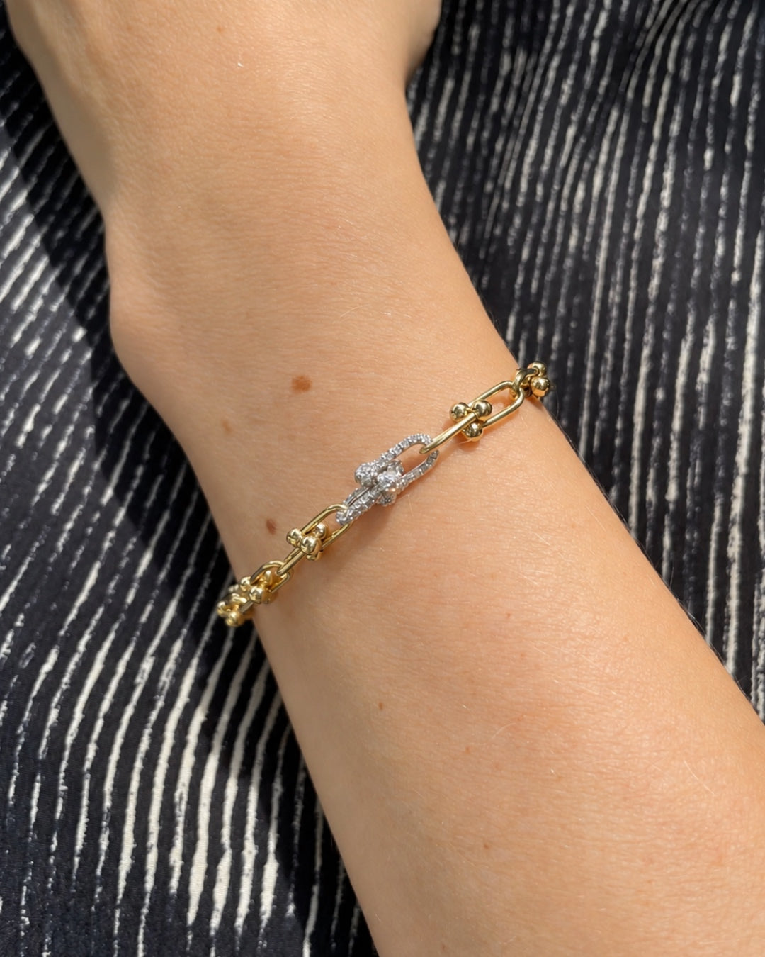 Close-up of a wrist wearing the Diamond and Gold Ball Link Bracelet in 14K yellow gold, highlighting the diamond-set links and polished gold ball accents.