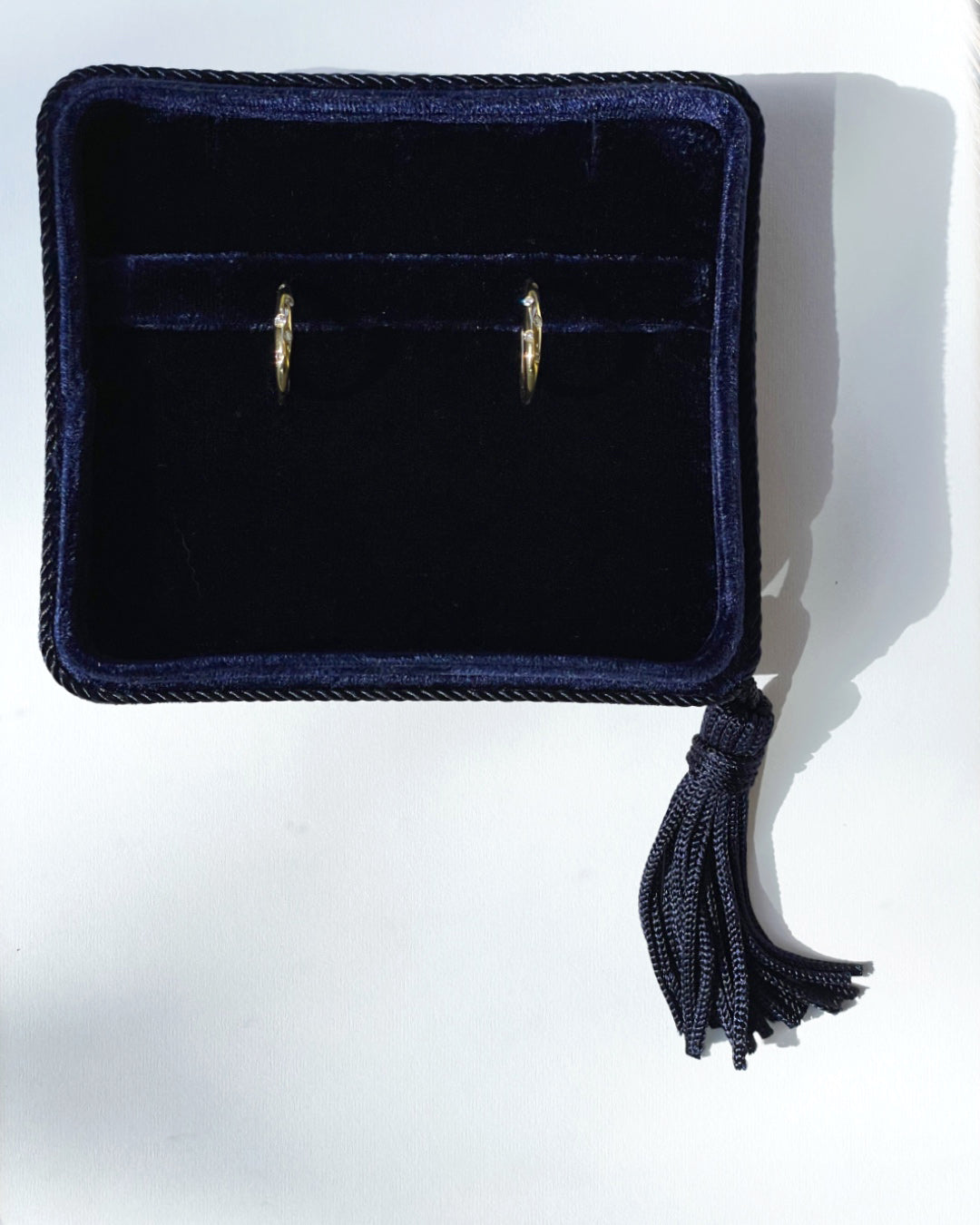 Galaxy Diamond Hoop Earrings in 14K yellow gold displayed in a navy velvet Marisa Perry jewelry box, featuring scattered round brilliant-cut diamonds in a burnished setting.