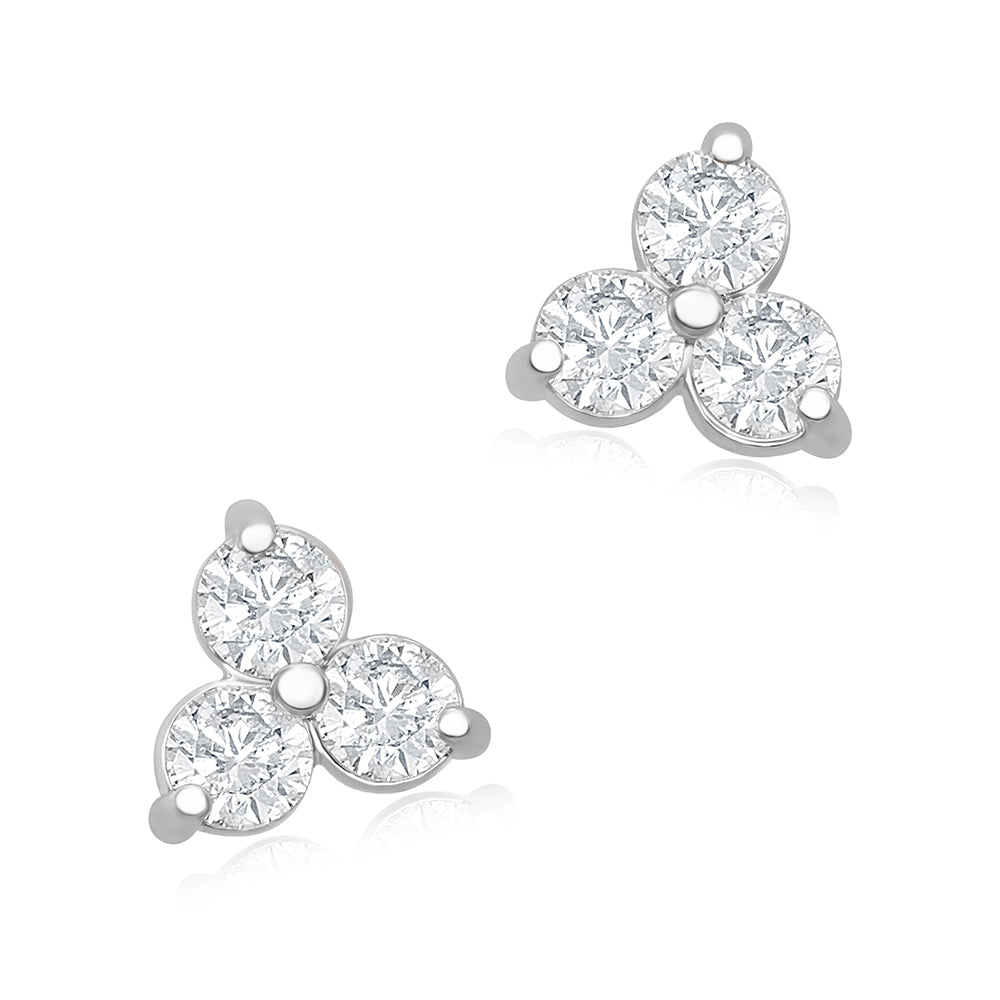 A pair of medium-sized white gold trilogy stud earrings, featuring three round brilliant cut diamonds.