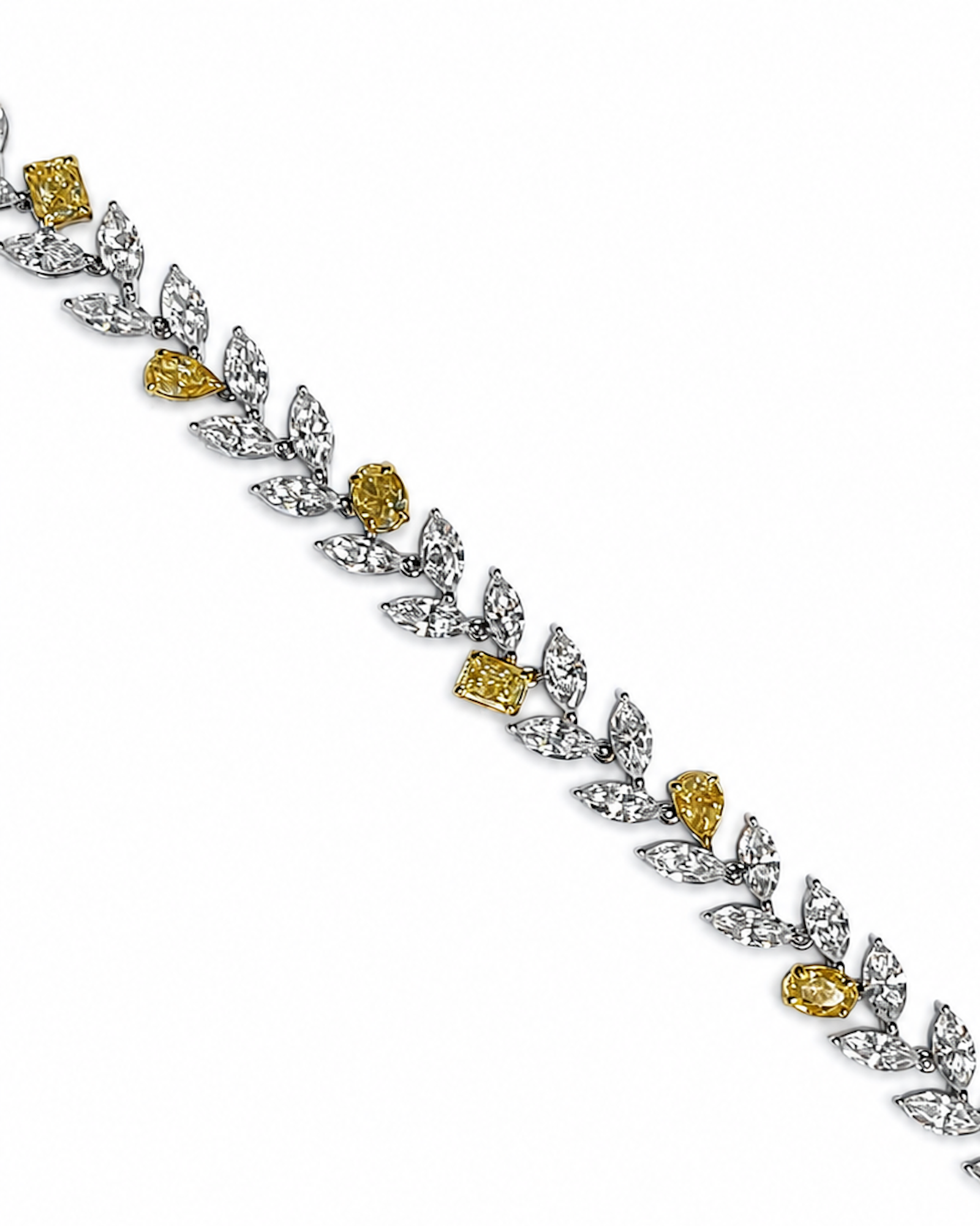 Mixed shape white and yellow diamond bracelet featuring marquise white diamonds and fancy yellow pear, oval, and cushion-cut diamonds.
