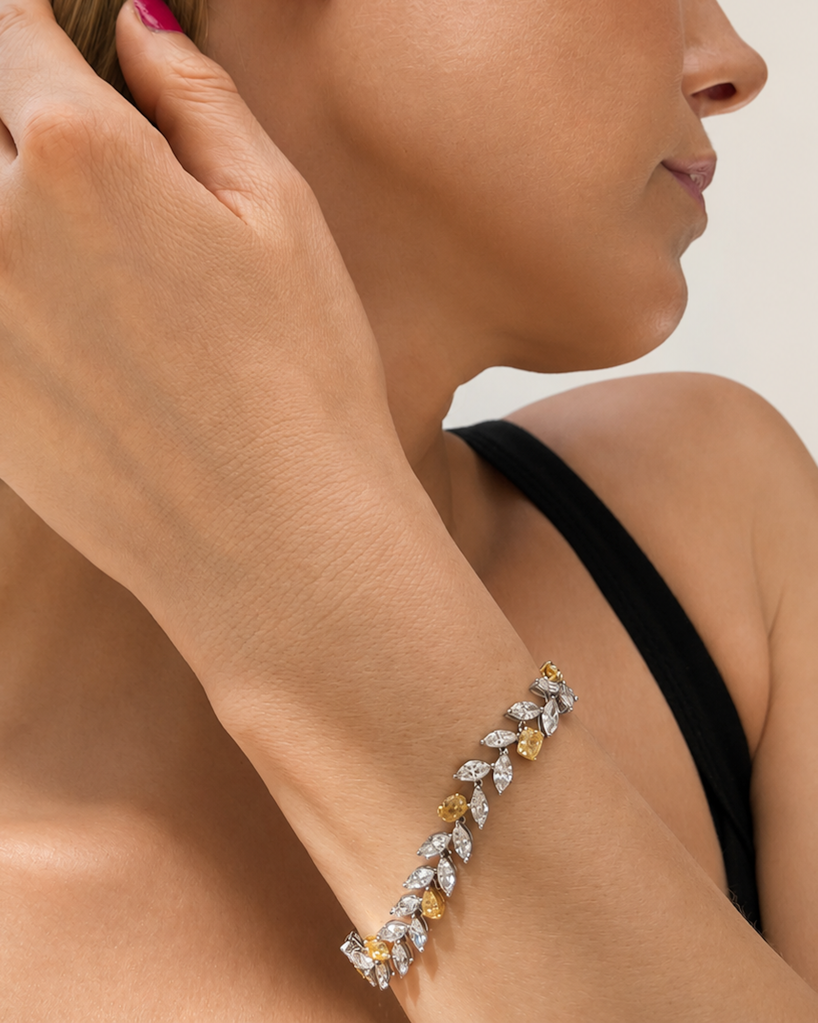 Model wearing a mixed shape white and yellow diamond bracelet featuring fancy yellow and white diamonds.