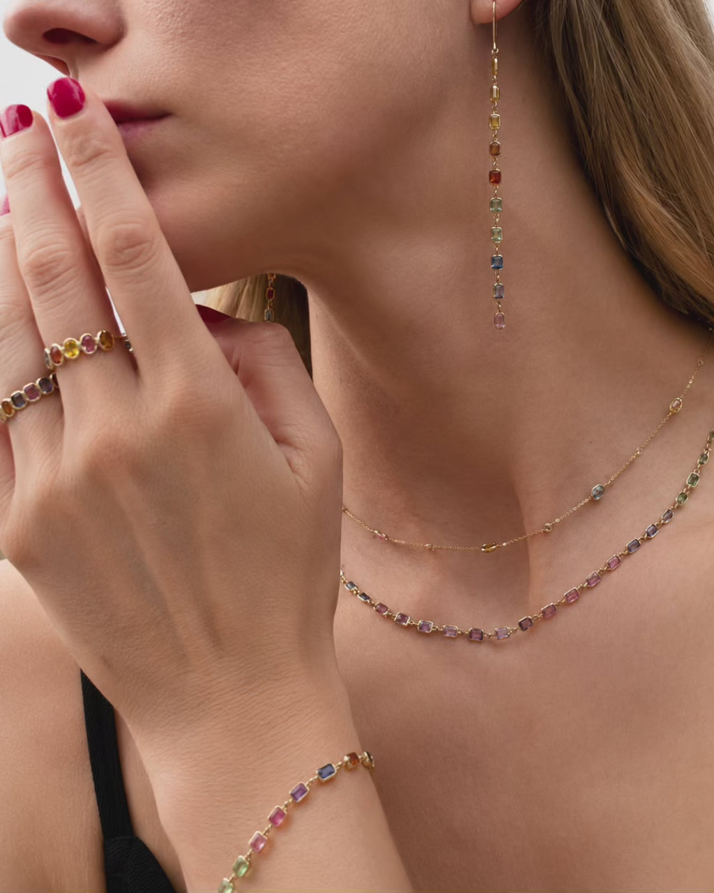 Video of model wearing a Rainbow Bezel Set Sapphire Ring featuring emerald-cut natural multicolor sapphires set in 14k yellow gold.