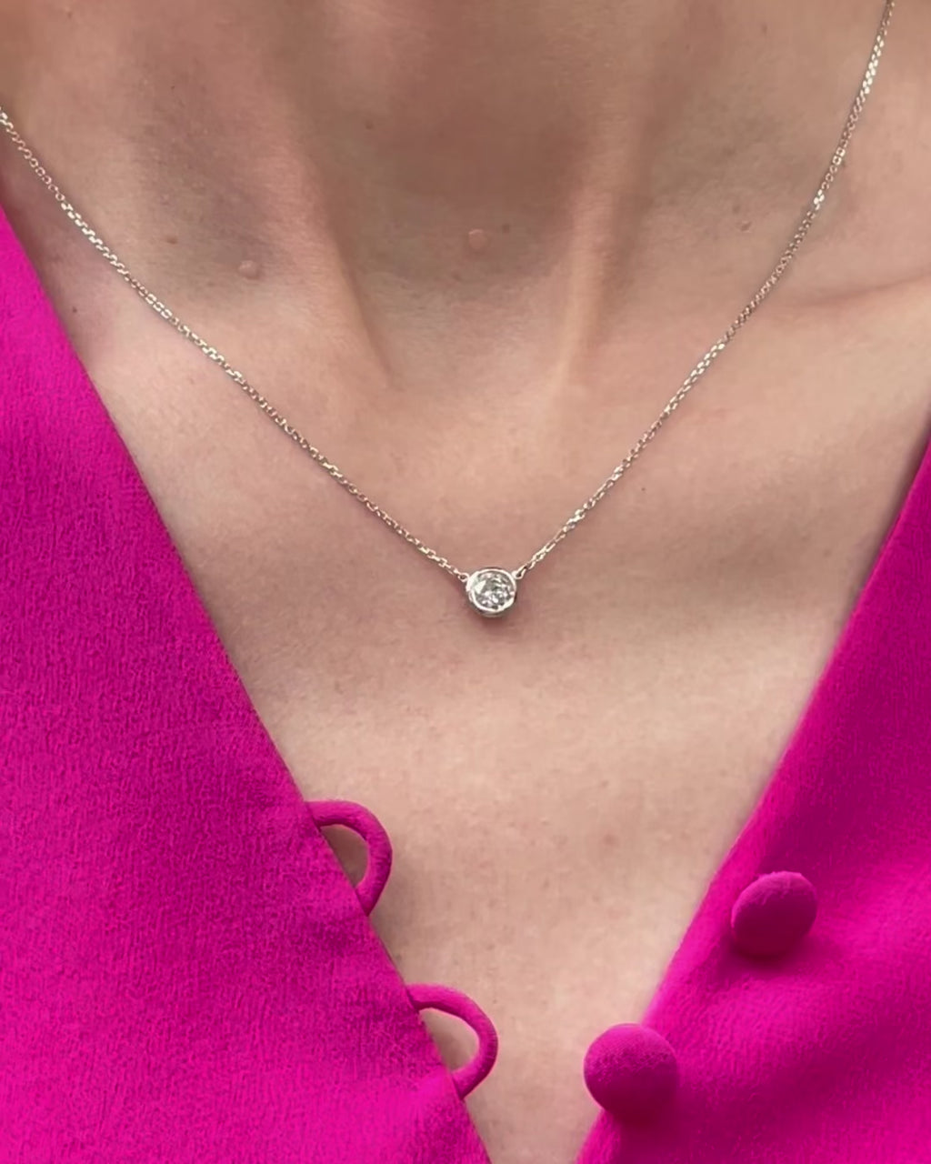 A model moving slowly, from far to close-up, showing details of the 0.40 ct bezel set diamond pendant necklace in 14k white gold.