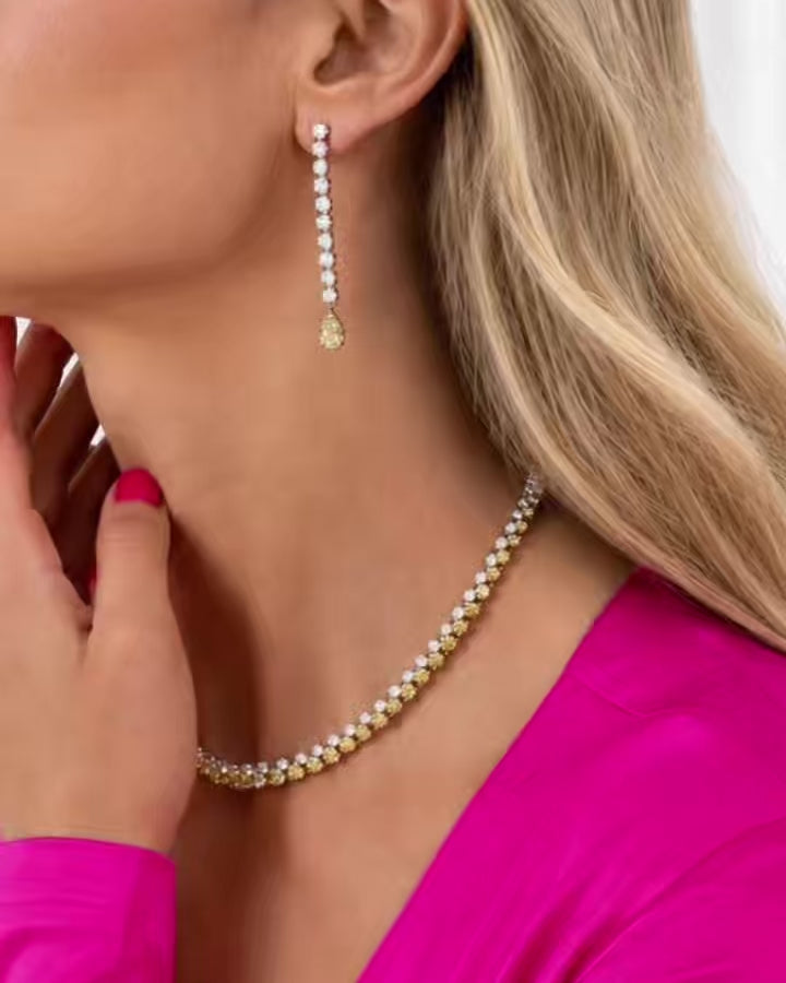 Model wearing coordinating white and yellow diamond jewelry, with close-up views highlighting a diamond necklace, bracelet, earrings, and ring.