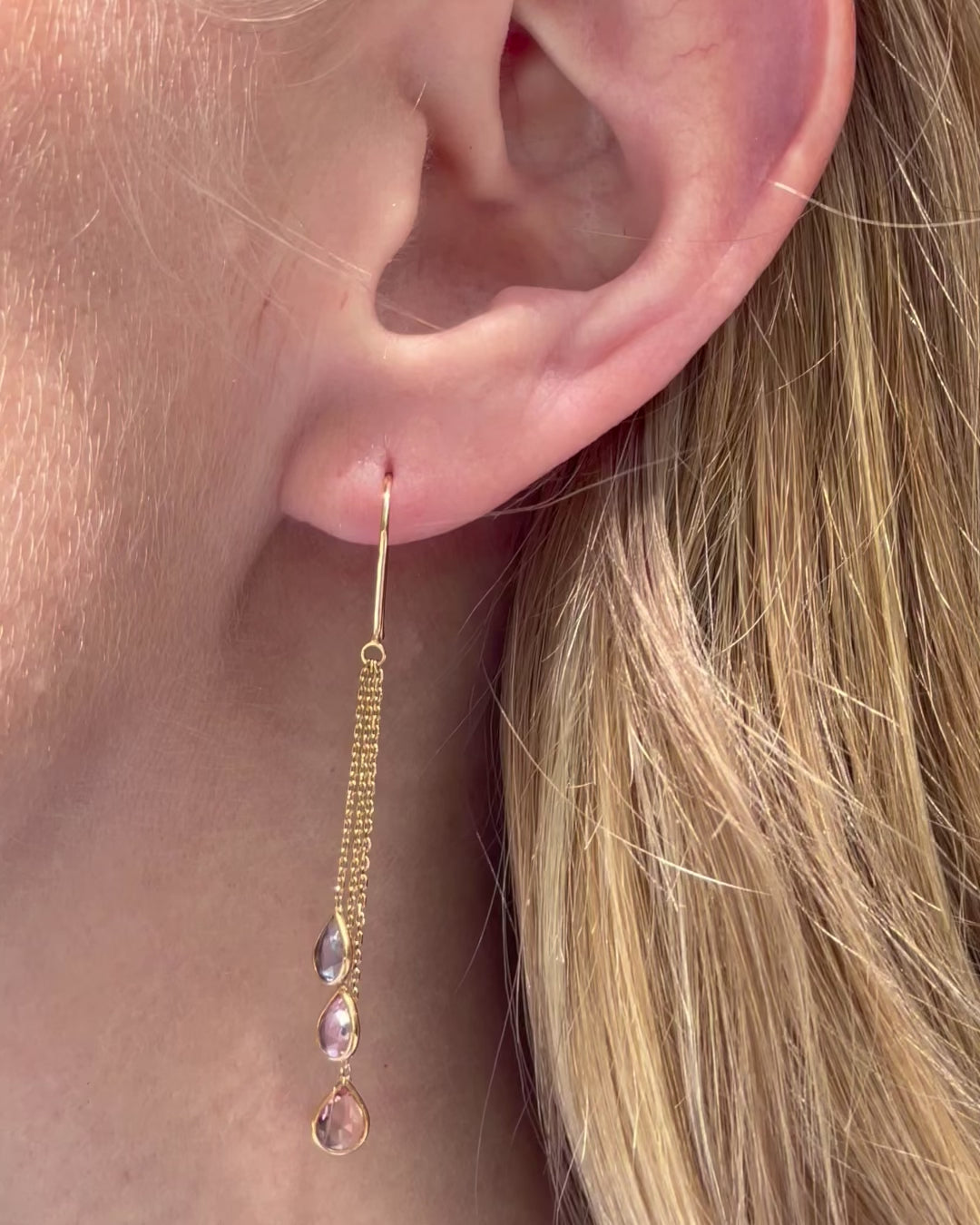 Model moving slowly, showing the graceful movement of the 18K yellow gold multi-color sapphire chain drop earrings with graduated pear-shaped diamonds.