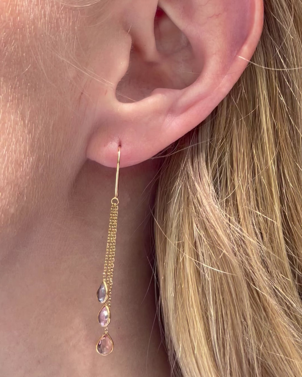 Model moving slowly, showing the graceful movement of the 18K yellow gold multi-color sapphire chain drop earrings with graduated pear-shaped diamonds.
