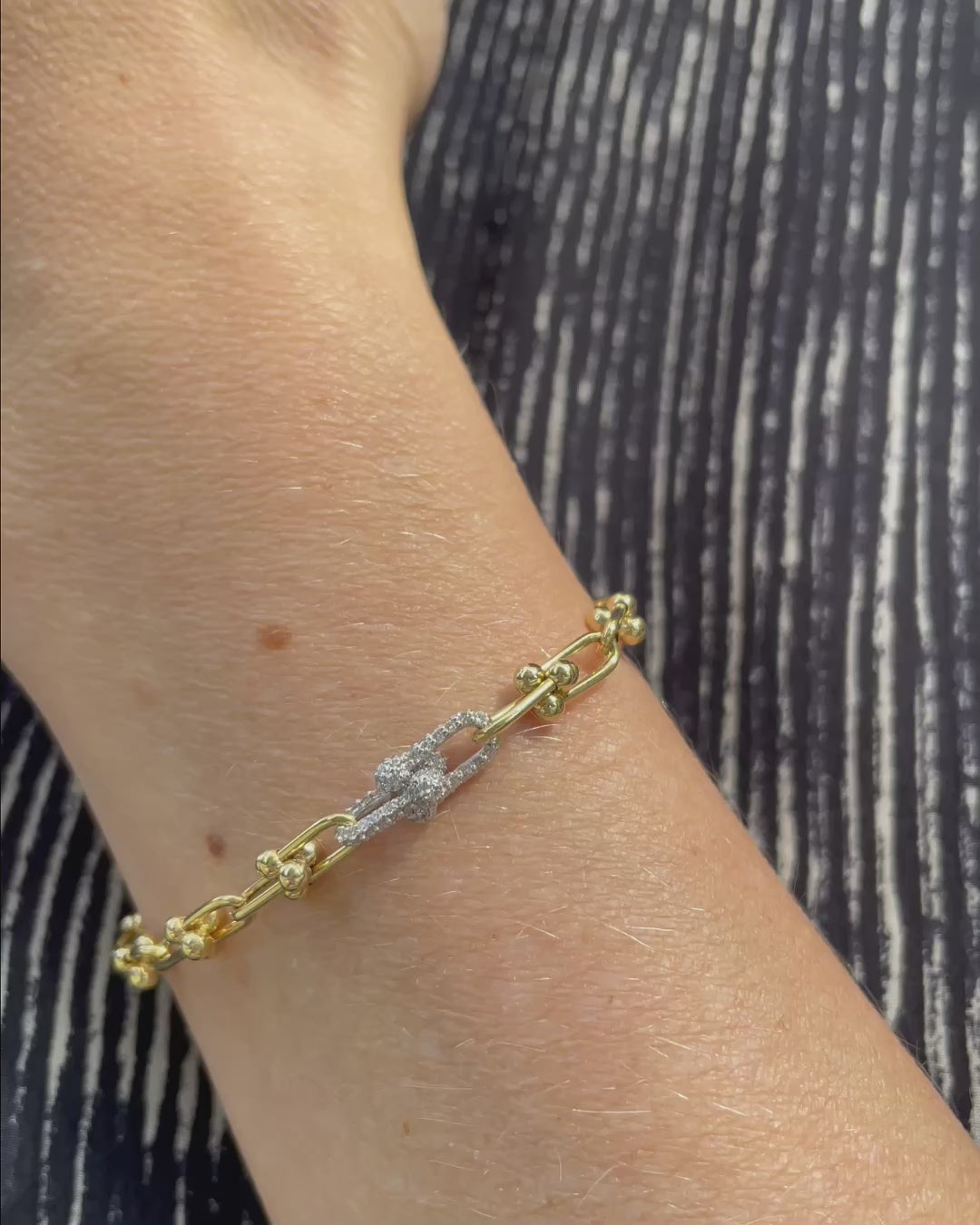 Diamond and Gold Ball Link Bracelet in 14K yellow gold shown on a wrist, followed by close-up views on a hand highlighting the polished gold ball accents and two diamond-set links totaling 0.50 TCW.
