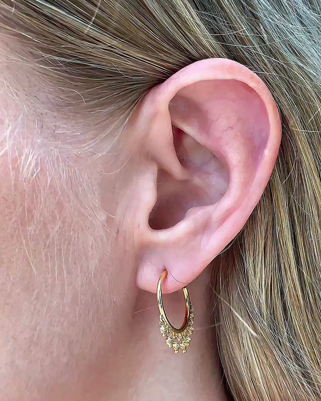 Model moving slowly, showing different angles of the 14K yellow gold open hoop beaded earrings with dangling diamond-cut bead accents.
