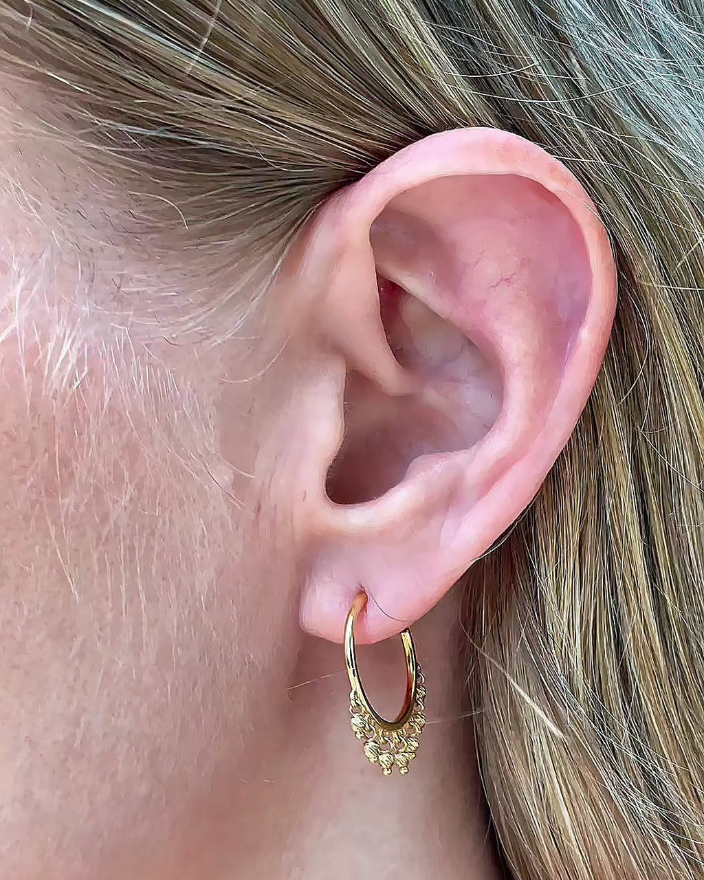 Model moving slowly, showing different angles of the 14K yellow gold open hoop beaded earrings with dangling diamond-cut bead accents.