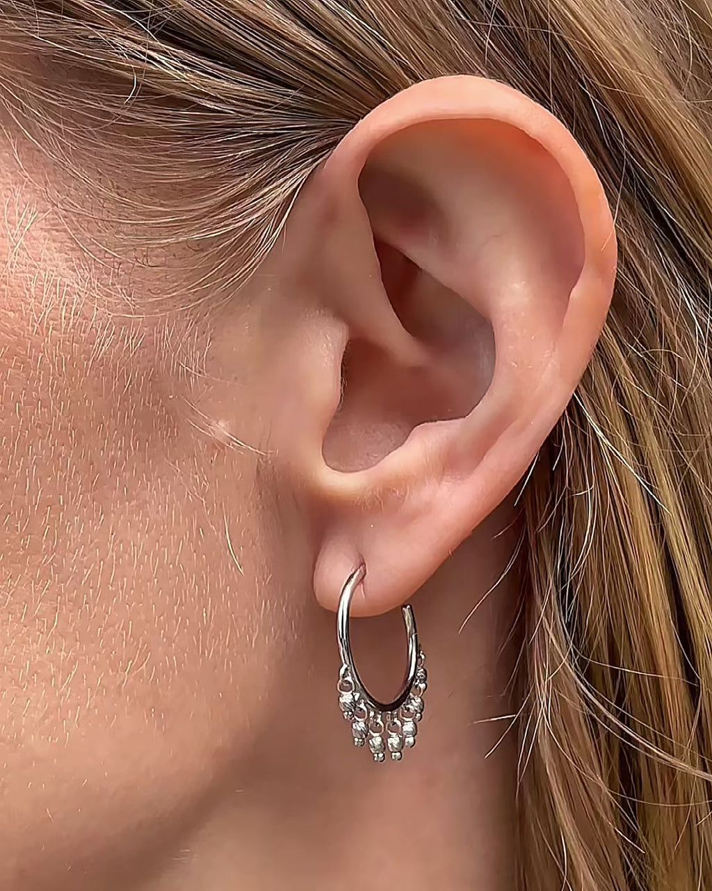 Model moving slowly, showing different angles of the 14K white gold open hoop beaded earrings with dangling diamond-cut bead accents.