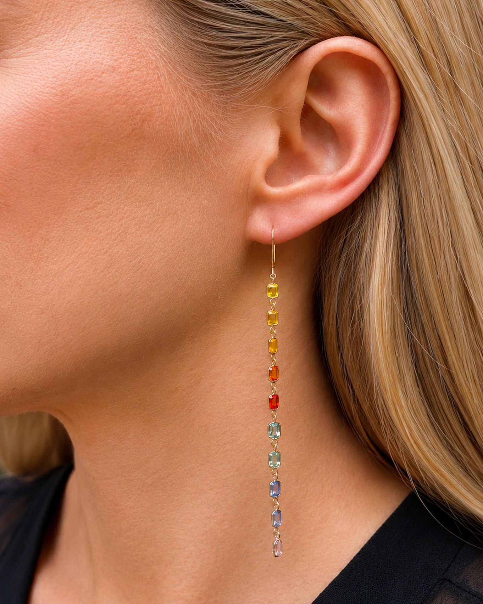 A model wearing rainbow sapphire bezel set drop earrings.