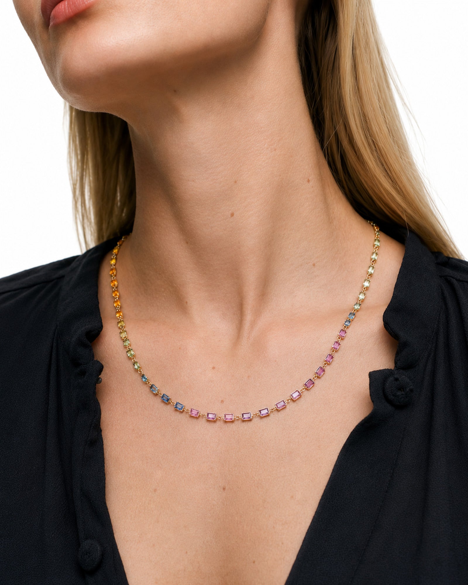 Model wearing a rainbow sapphire bezel set necklace with emerald-cut natural multicolor sapphires set in 14K yellow gold.