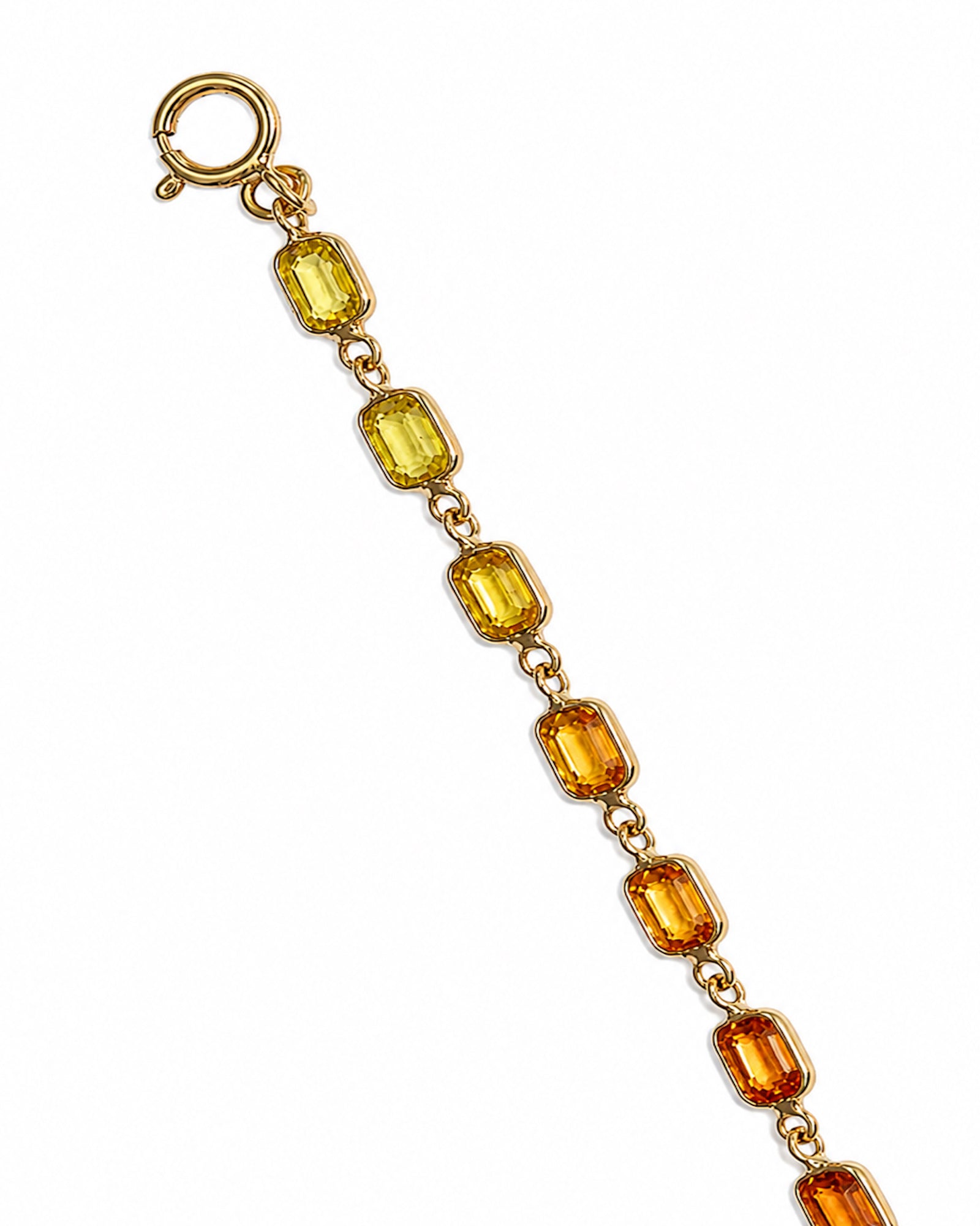 Close-up of a rainbow sapphire bezel set tennis bracelet with emerald-cut natural multicolor sapphires in 14K yellow gold.