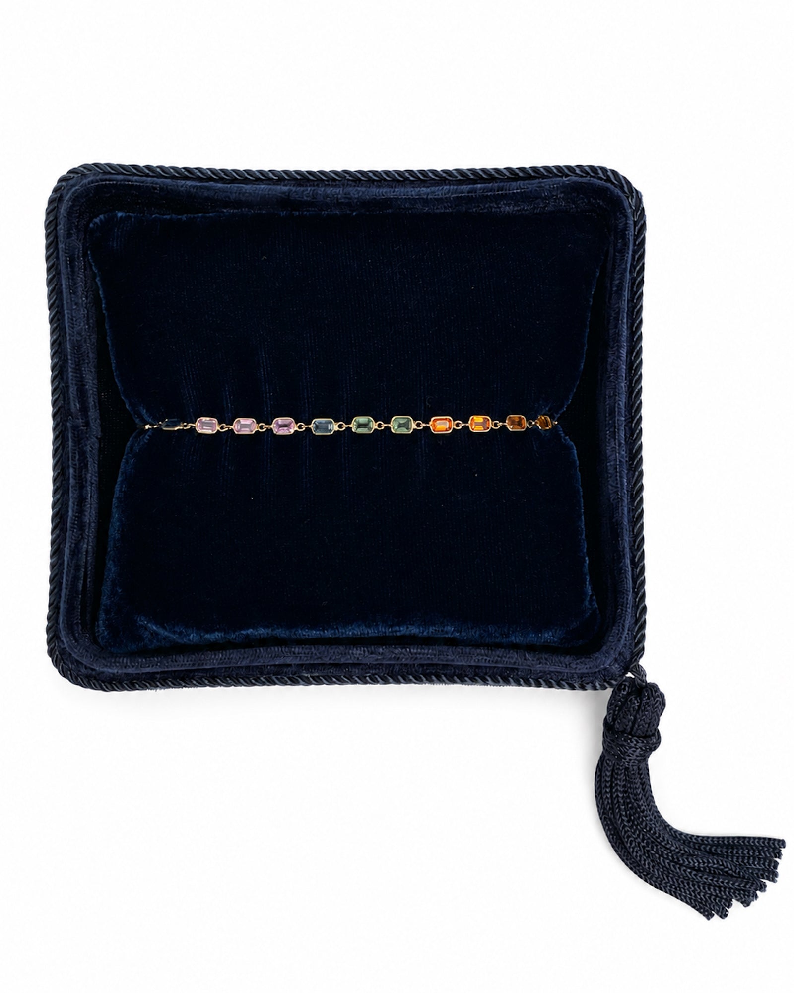 Rainbow Sapphire Bezel Set Tennis Bracelet displayed in a navy velvet Marisa Perry jewelry box.