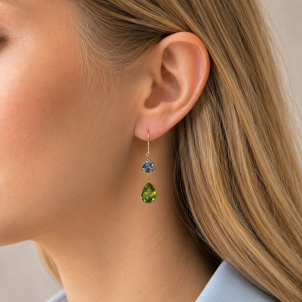 Close-up of a blonde model wearing Tanzanite and Peridot drop earrings.